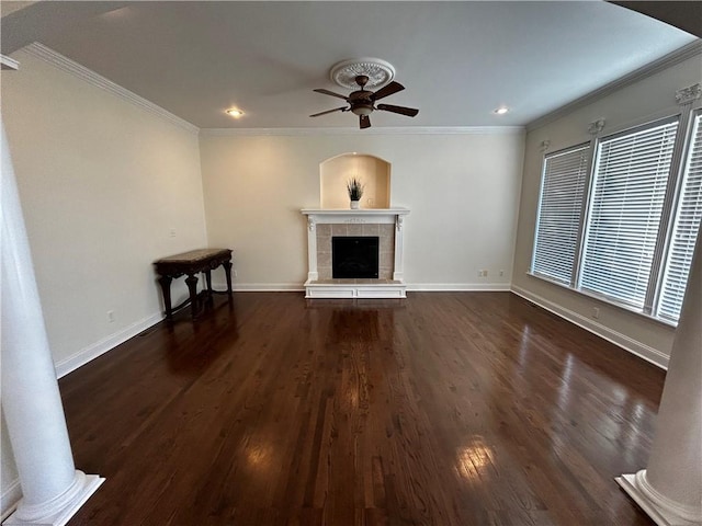 unfurnished living room featuring ceiling fan, a fireplace, dark wood-type flooring, and crown molding