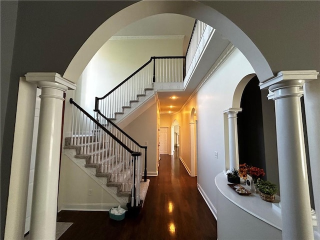 stairs featuring crown molding, a high ceiling, and hardwood / wood-style flooring