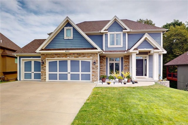 craftsman inspired home with a garage and a front lawn