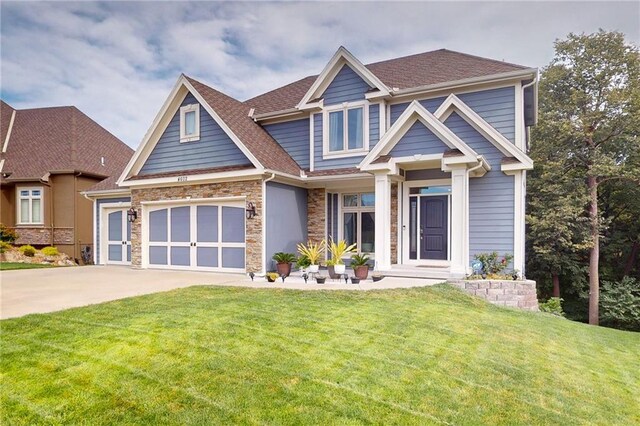 4602 NW Verona Dr, Riverside, MO 64150 - craftsman-style house with stone siding, driveway, a front yard, and a shingled roof