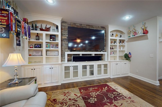 living room with built in shelves and dark wood-type flooring