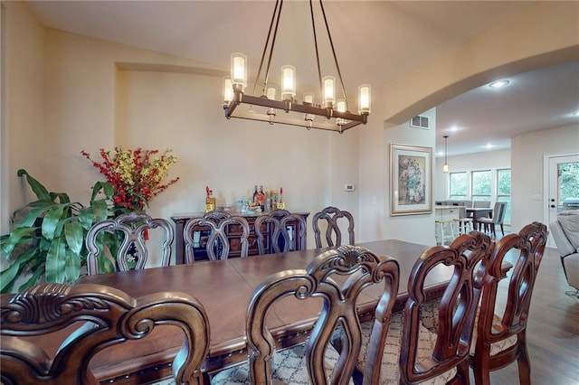 dining space with an inviting chandelier and dark wood-type flooring