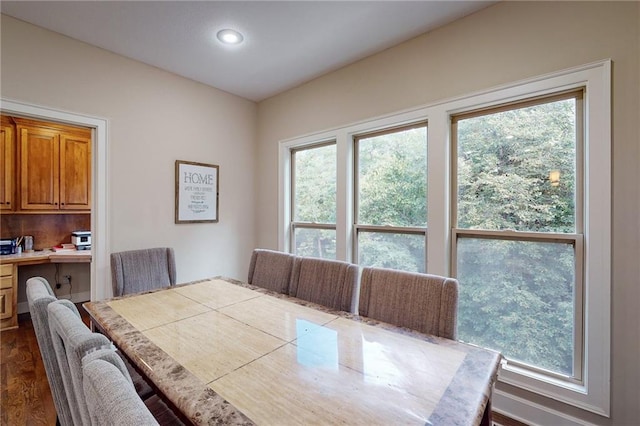 dining area with built in desk and dark hardwood / wood-style flooring