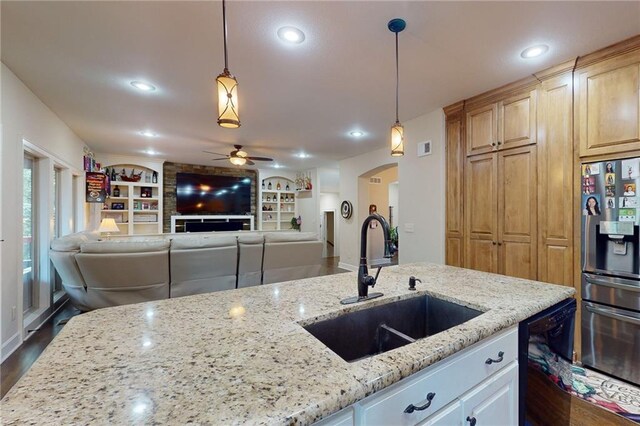 4602 NW Verona Dr, Riverside, MO 64150 - kitchen featuring a sink, stainless steel fridge, a ceiling fan, arched walkways, and light stone countertops