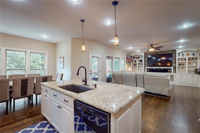 kitchen featuring white cabinets, sink, decorative light fixtures, a kitchen island with sink, and dishwasher