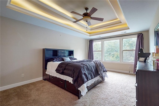 bedroom with ceiling fan, a raised ceiling, light carpet, and ornamental molding