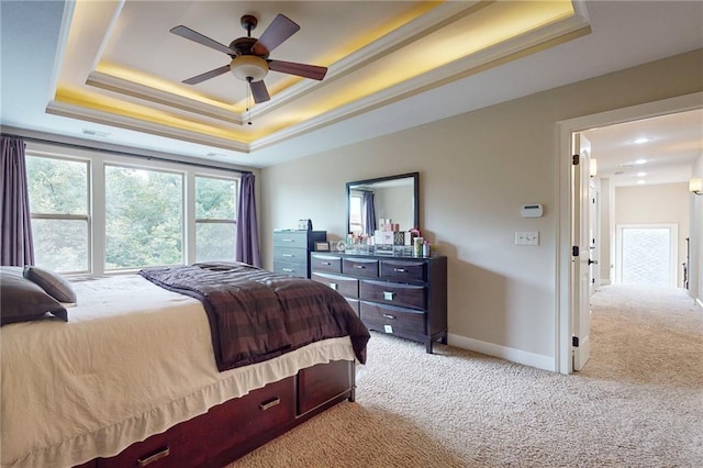 bedroom with ceiling fan, light colored carpet, a raised ceiling, and ornamental molding