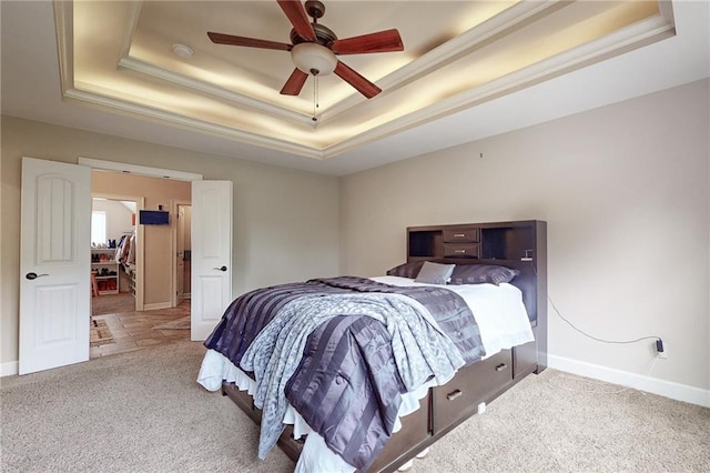 carpeted bedroom featuring ceiling fan and a raised ceiling