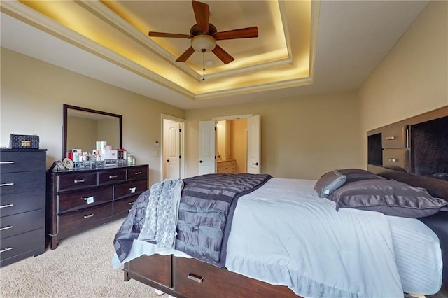 carpeted bedroom with a raised ceiling and ceiling fan