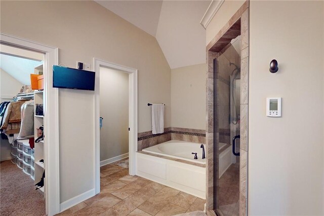 4602 NW Verona Dr, Riverside, MO 64150 - bathroom featuring a garden tub, a walk in closet, a stall shower, vaulted ceiling, and baseboards