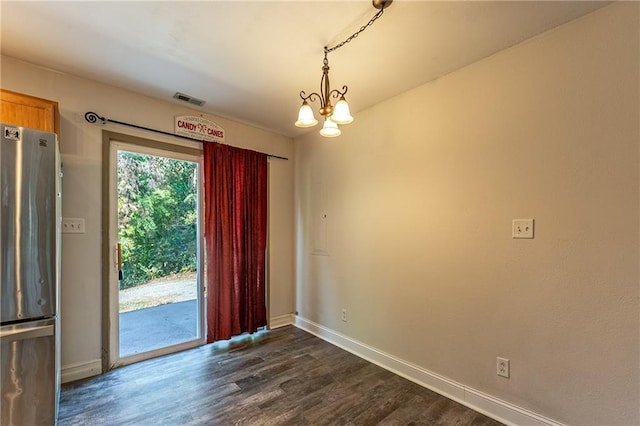 unfurnished room featuring dark wood-type flooring, a notable chandelier, baseboards, and visible vents