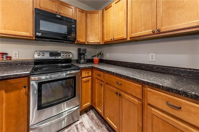 kitchen featuring brown cabinetry, light wood-style floors, black microwave, and stainless steel range with electric cooktop