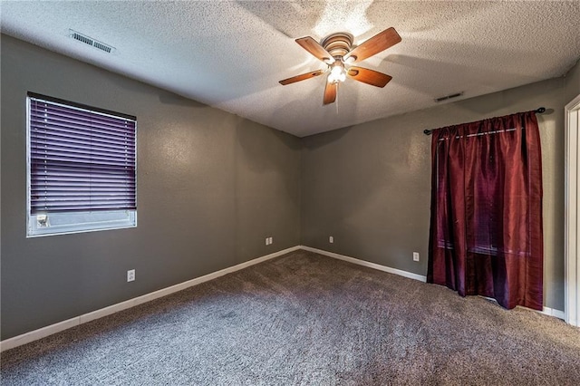 carpeted spare room featuring visible vents, a textured ceiling, and a ceiling fan