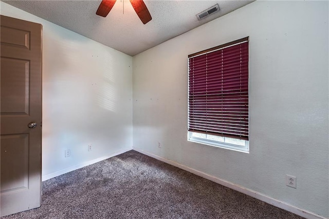 spare room featuring visible vents, a textured ceiling, ceiling fan, and carpet flooring