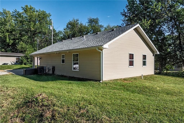 view of home's exterior featuring a lawn and a shingled roof