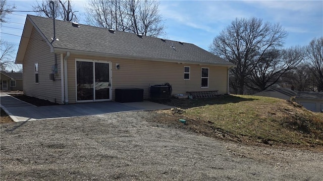 back of property with a patio area and roof with shingles