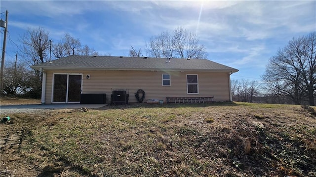 rear view of property with a patio, a lawn, and central AC