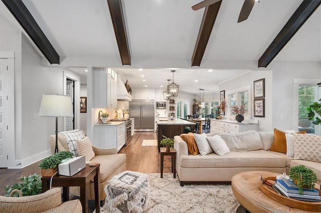 living room with beamed ceiling, ceiling fan, and light hardwood / wood-style flooring