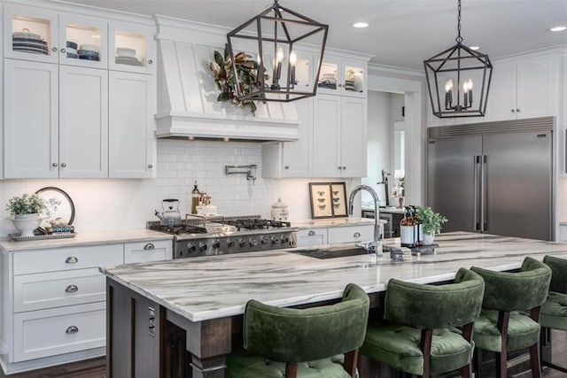 kitchen with white cabinets, a center island with sink, sink, and appliances with stainless steel finishes