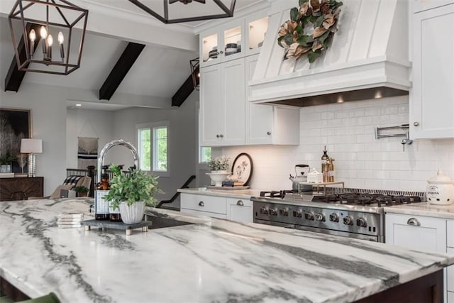 kitchen featuring white cabinets, premium range hood, tasteful backsplash, and stainless steel range