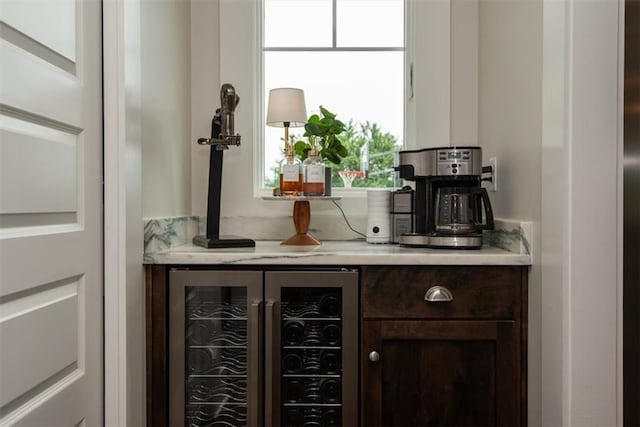 bar with dark brown cabinets and wine cooler