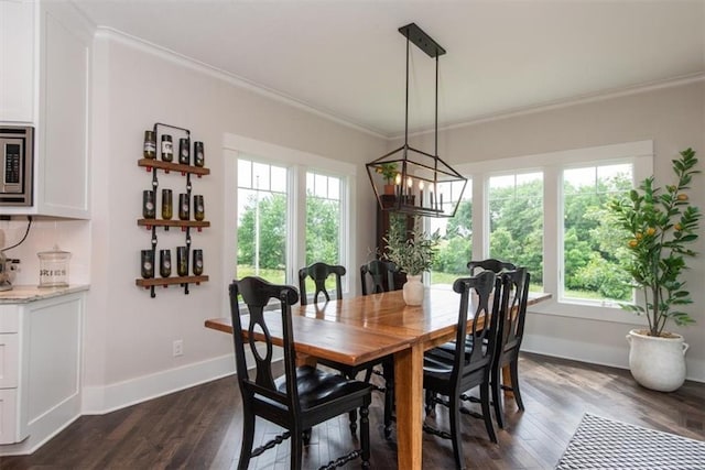 dining area featuring dark hardwood / wood-style flooring, crown molding, and a healthy amount of sunlight