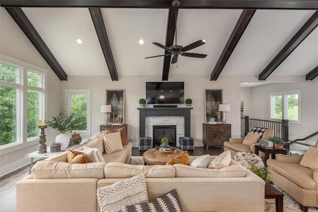 living room featuring vaulted ceiling with beams, light hardwood / wood-style floors, and plenty of natural light