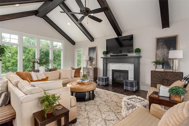 living room featuring a fireplace, lofted ceiling with beams, ceiling fan, and dark wood-type flooring