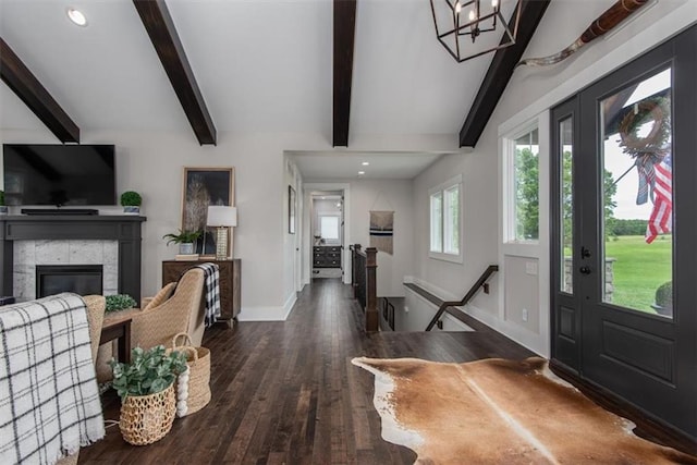 entryway featuring a fireplace, vaulted ceiling with beams, dark hardwood / wood-style floors, and an inviting chandelier