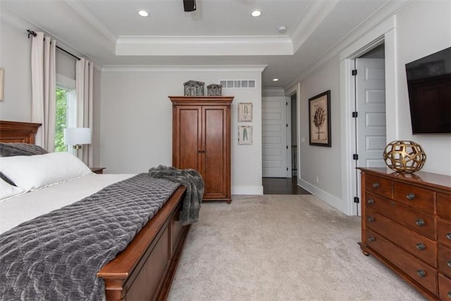 carpeted bedroom featuring a tray ceiling and ornamental molding