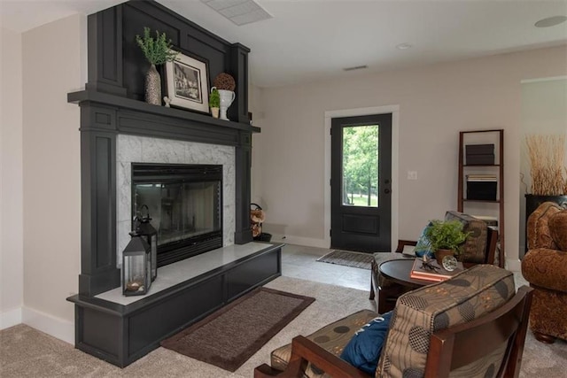 carpeted living room with a tile fireplace