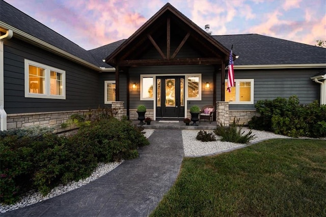 view of front of property featuring covered porch and a yard