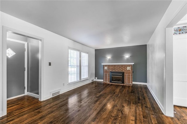 unfurnished living room featuring a fireplace and dark wood-type flooring