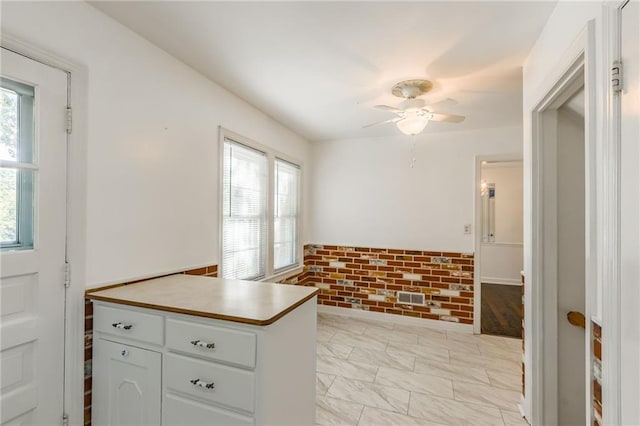 kitchen with white cabinets and ceiling fan