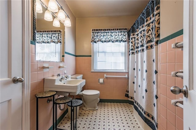 bathroom with tile walls, a shower with curtain, and toilet