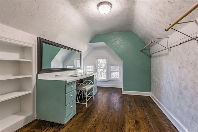 interior space featuring vaulted ceiling, dark hardwood / wood-style floors, and built in features