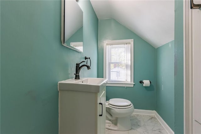 bathroom featuring vaulted ceiling, toilet, and vanity