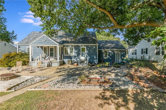 back of property with a patio and an outdoor fire pit