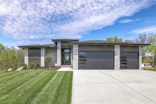 prairie-style home featuring a garage and a front lawn