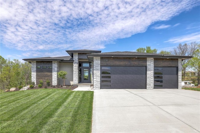 prairie-style house with stone siding, concrete driveway, a garage, and a front yard