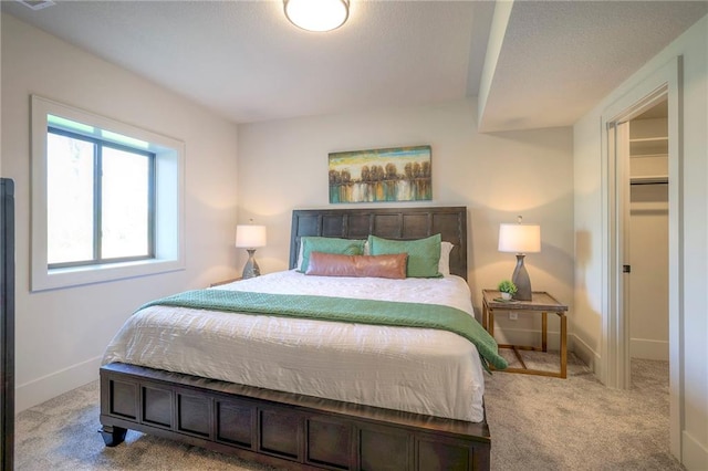 bedroom with a spacious closet and light colored carpet