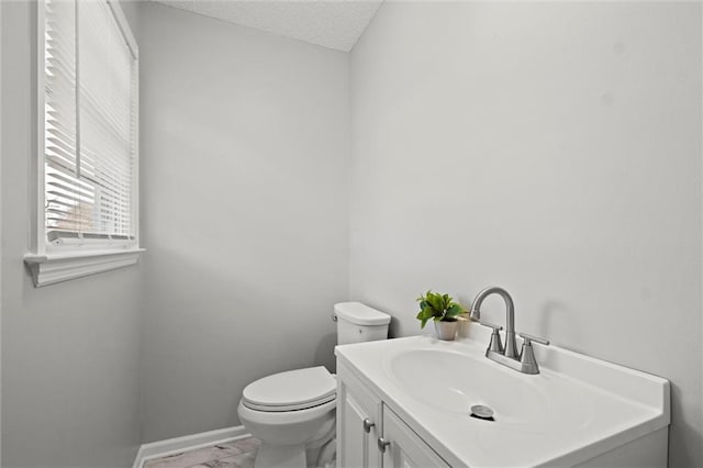 bathroom with vanity, toilet, and a textured ceiling