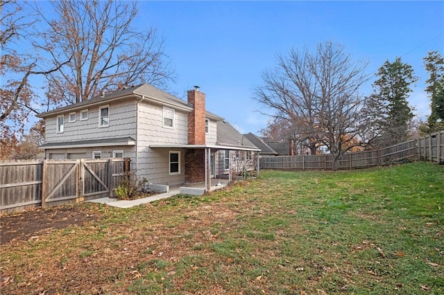 rear view of property featuring a lawn