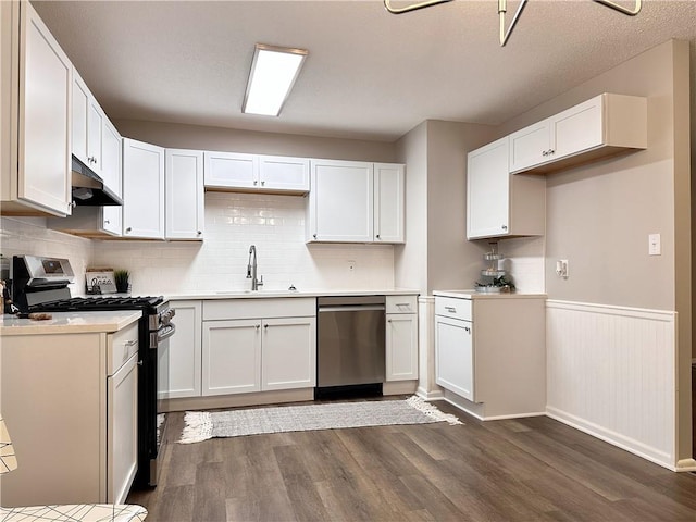 kitchen featuring decorative backsplash, dark hardwood / wood-style floors, sink, white cabinetry, and appliances with stainless steel finishes