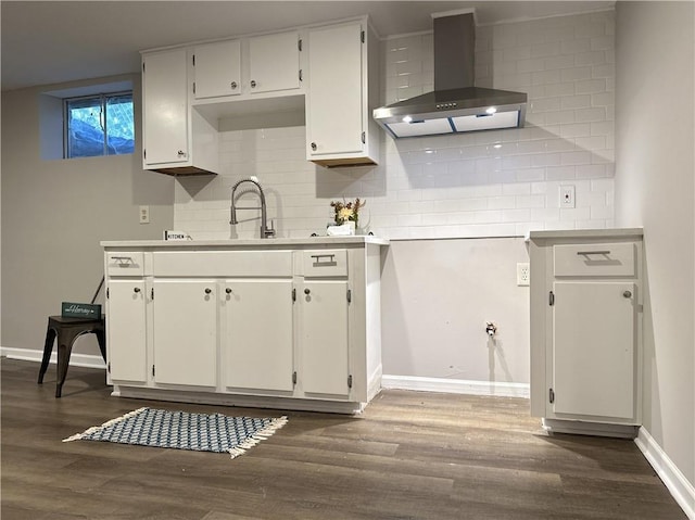 kitchen featuring wall chimney exhaust hood, white cabinetry, backsplash, and dark hardwood / wood-style flooring