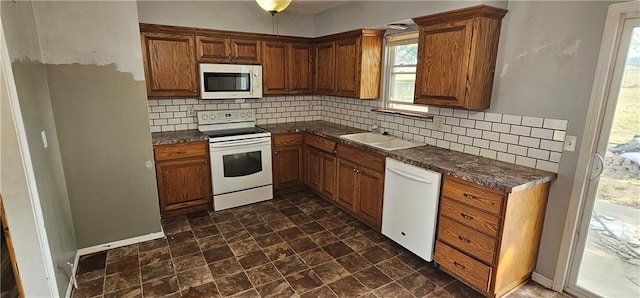 kitchen featuring decorative backsplash, white appliances, and sink