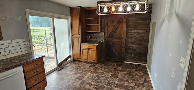 kitchen with white dishwasher, decorative light fixtures, dark stone counters, and decorative backsplash