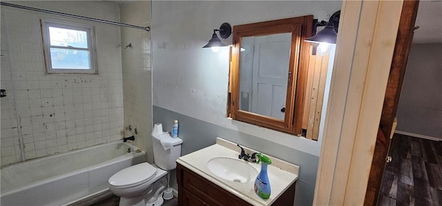 full bathroom with tiled shower / bath, vanity, toilet, and hardwood / wood-style flooring