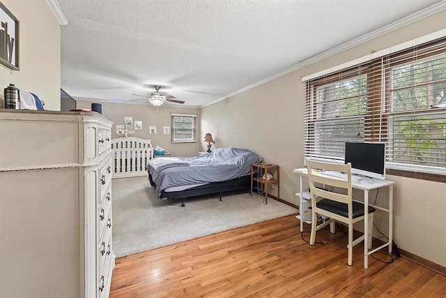 bedroom with a textured ceiling, ornamental molding, ceiling fan, and hardwood / wood-style flooring