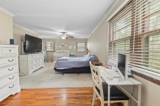 bedroom featuring a textured ceiling, light hardwood / wood-style floors, ornamental molding, and ceiling fan